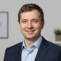 Портрет уверенного российского бизнесмена с дружелюбным взглядом на размытом нейтральном фоне в студии