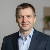 Портрет уверенного российского бизнесмена с дружелюбным взглядом на размытом нейтральном фоне в студии